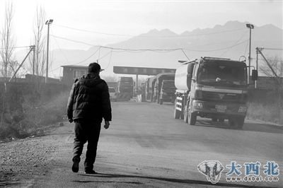 暗道与张山营检查站复检口出口路的交叉口，一男子在此指挥车辆。 