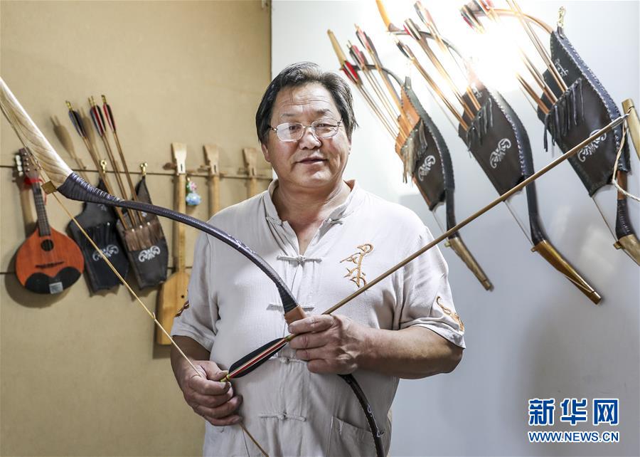 来自新疆伊犁哈萨克自治州察布查尔锡伯自治县的弓箭艺人赵玉书在工作室内展示自己制作的传统弓箭（2018年9月14日摄）。