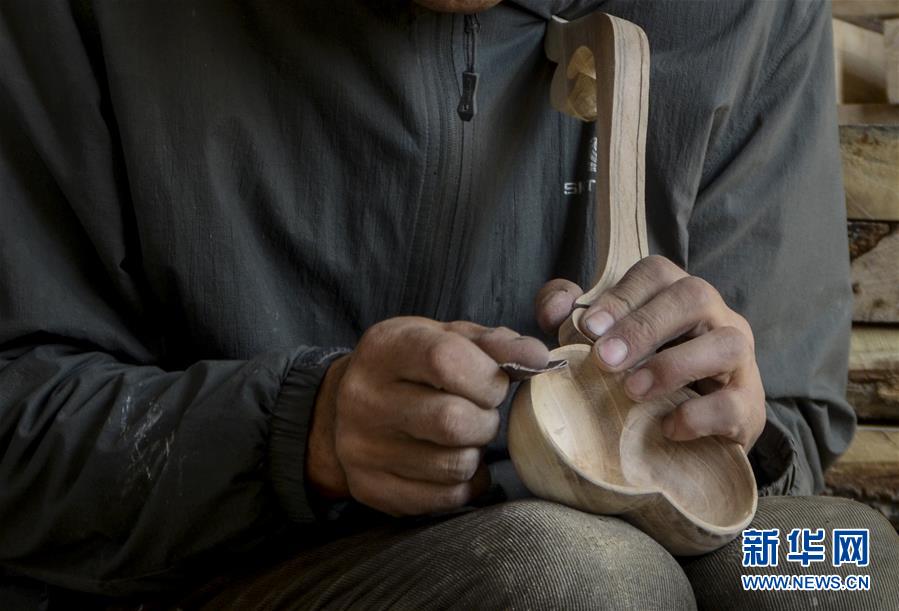 新疆乌鲁木齐县甘沟乡哈萨克族民间木制餐具传承人叶尔布力·白山在制作木碗（2016年9月30日摄）。